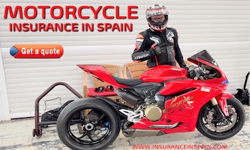 Motorcycle racer standing besides a red Ducati Panigali in the pits at a racetrack in Valencia 